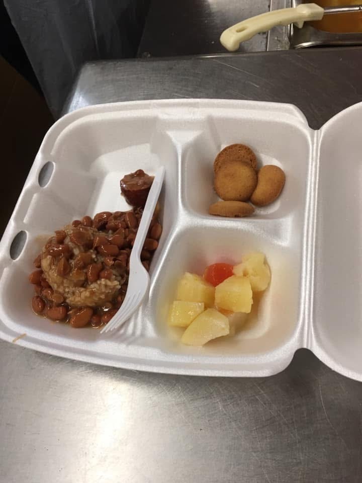 Prepared meal with beans, an entree, fruit, and crackers